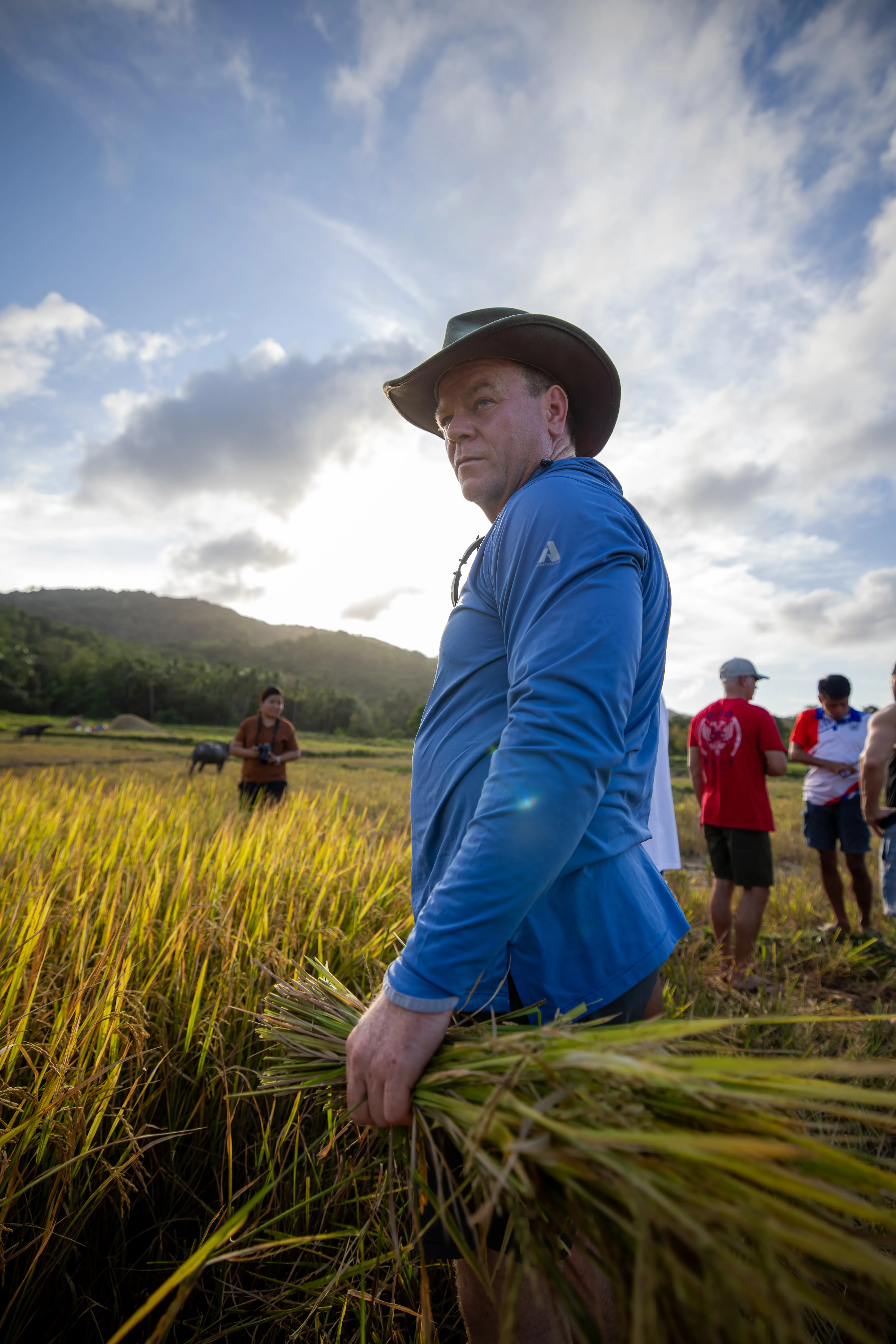 Daniel Ramsey in the Philippines, harvesting rice